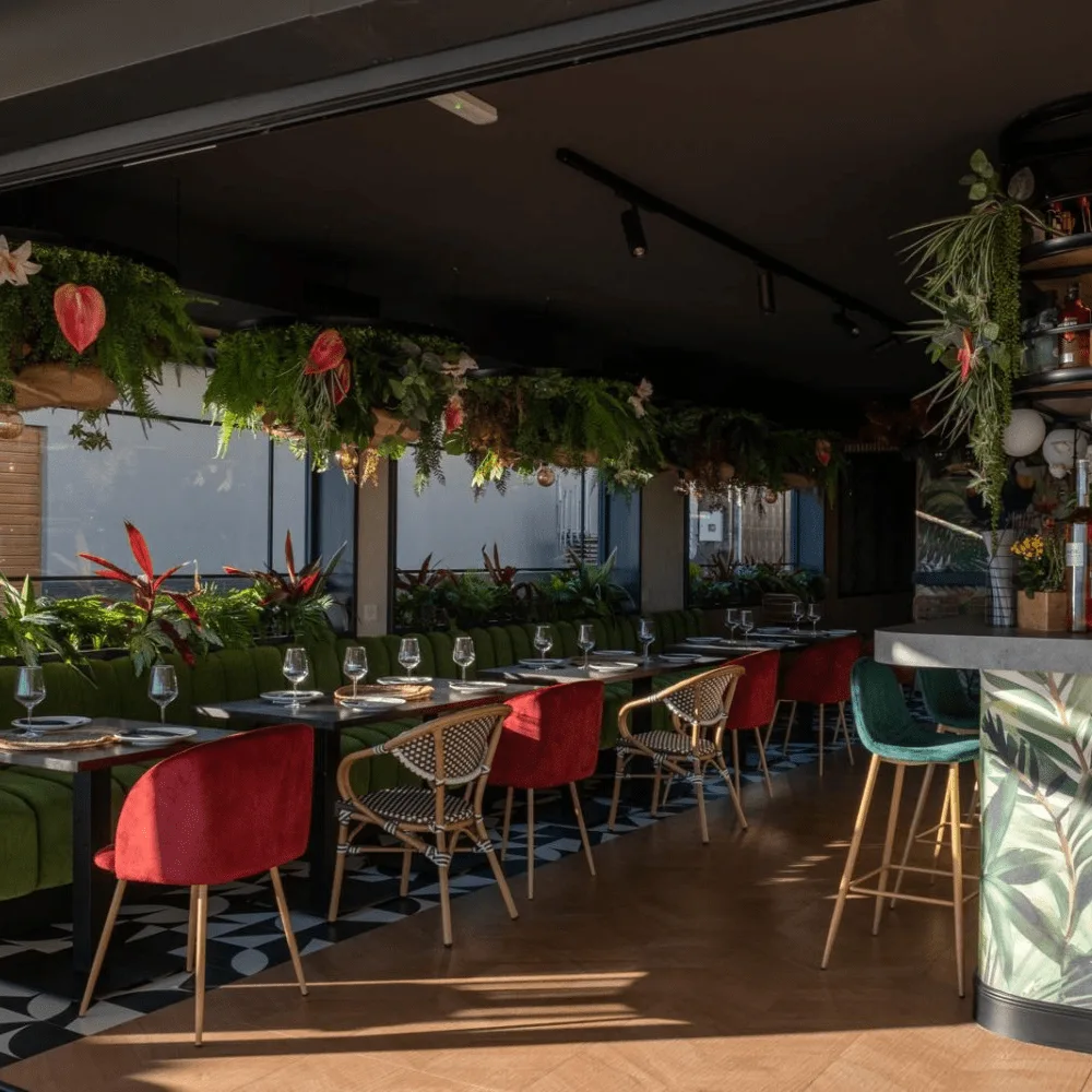 Comedor de restaurante con vegetación artificial colgante sobre las mesas