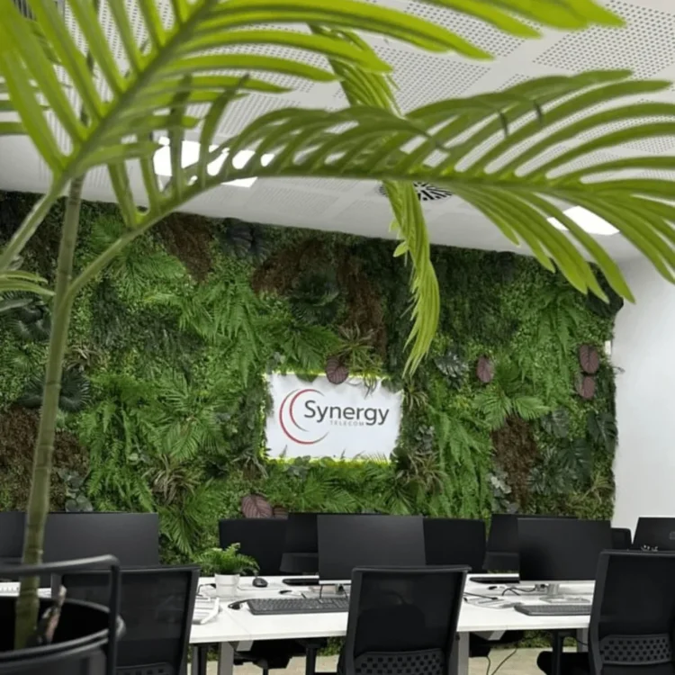 Pared vegetal artificial con el logotipo de la empresa en una sala de oficinas