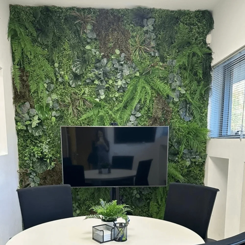 Pared vegetal artificial con pantalla integrada en una sala de reuniones