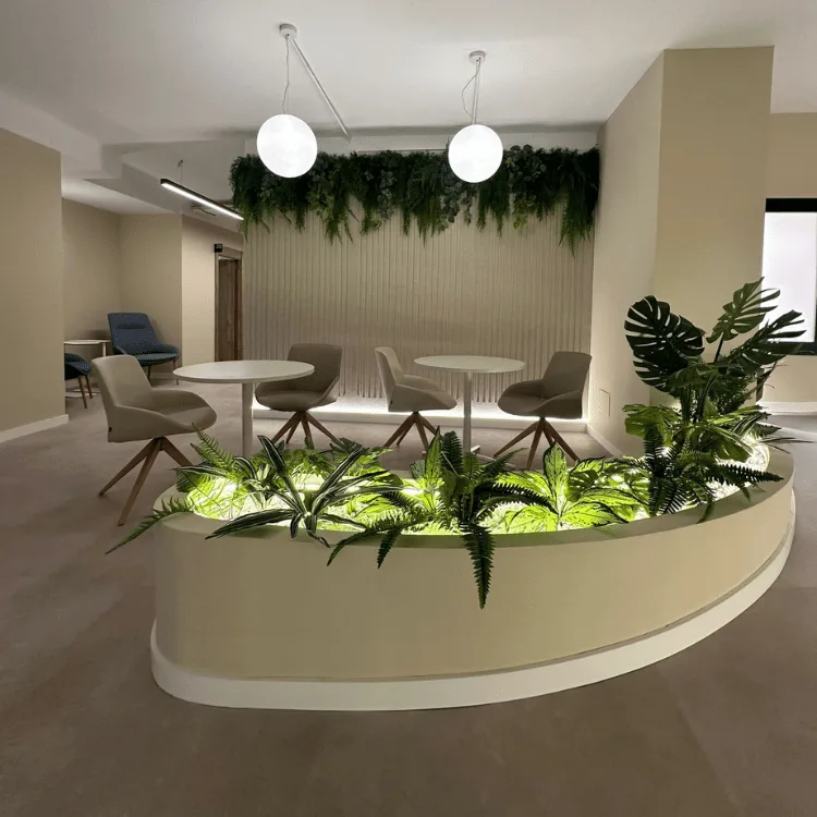 Showroom con jardinera de helechos artificiales iluminada y zona de reunión