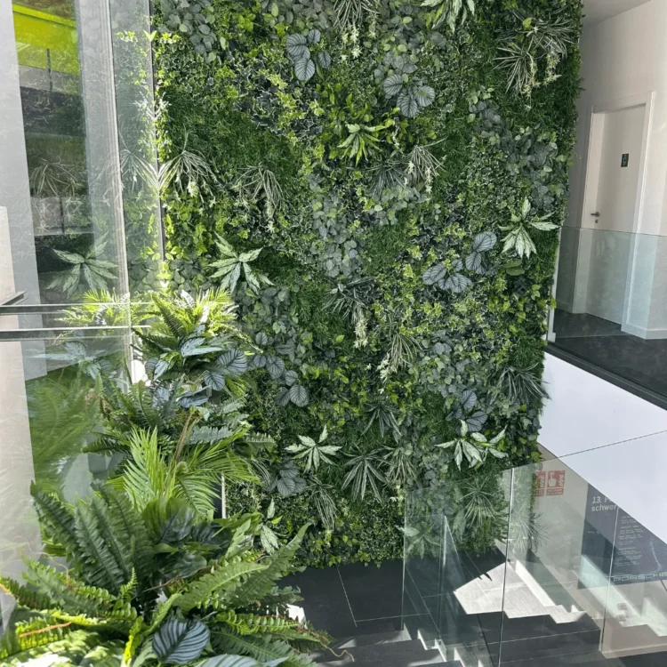 Jardín vertical artificial de doble altura en el patio acristalado de unas oficinas