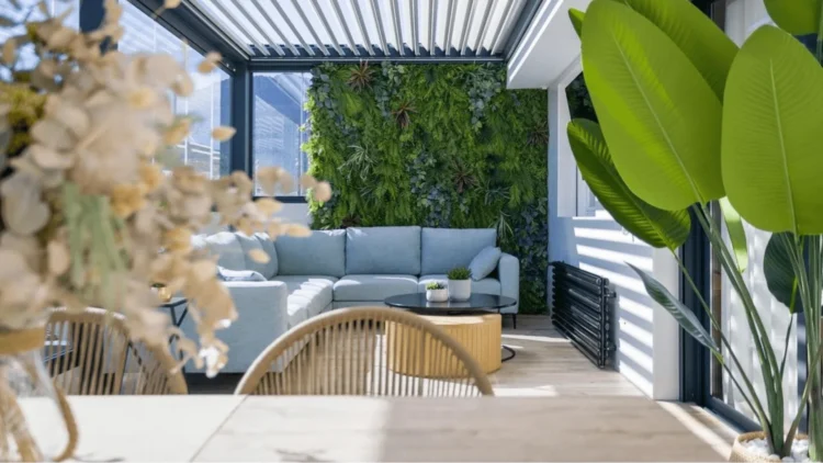 Jardín vertical artificial en una terraza cubierta con sofá y mesa de centro