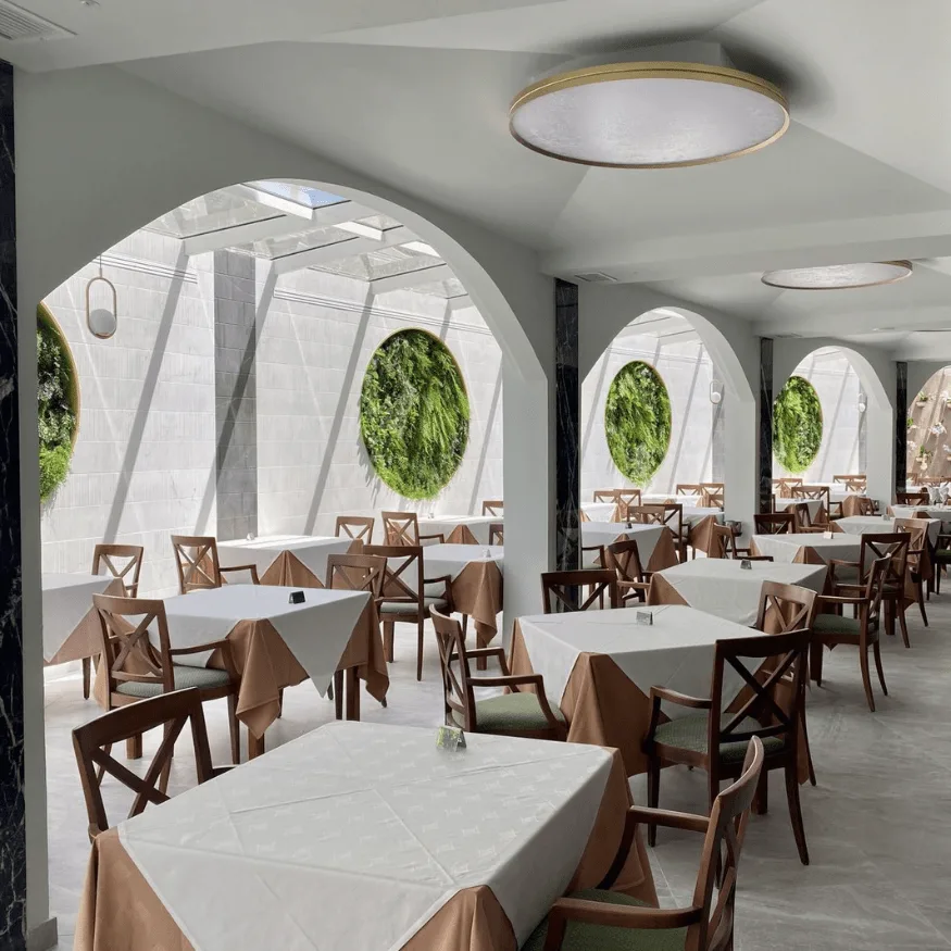 Comedor de restaurante con cuadros vegetales circulares en los arcos de la pared