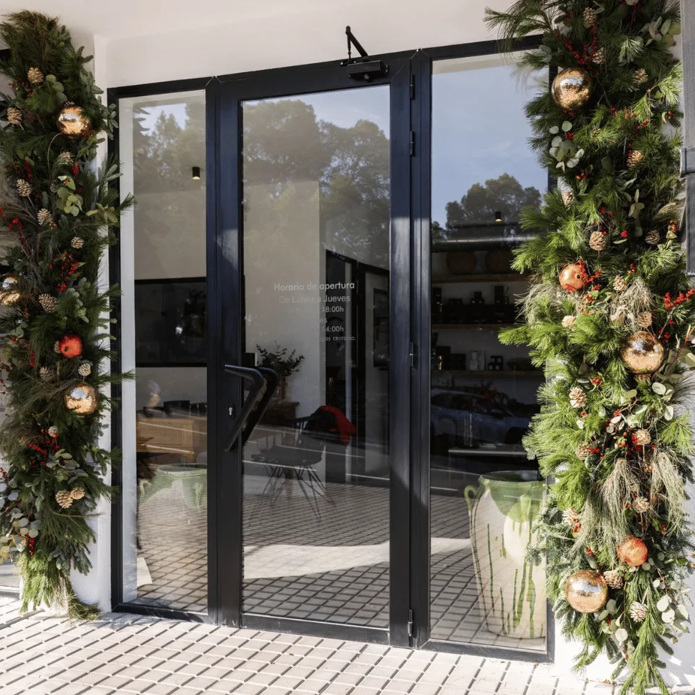 Entrada de un local con guirnaldas navideñas de vegetación en las jambas