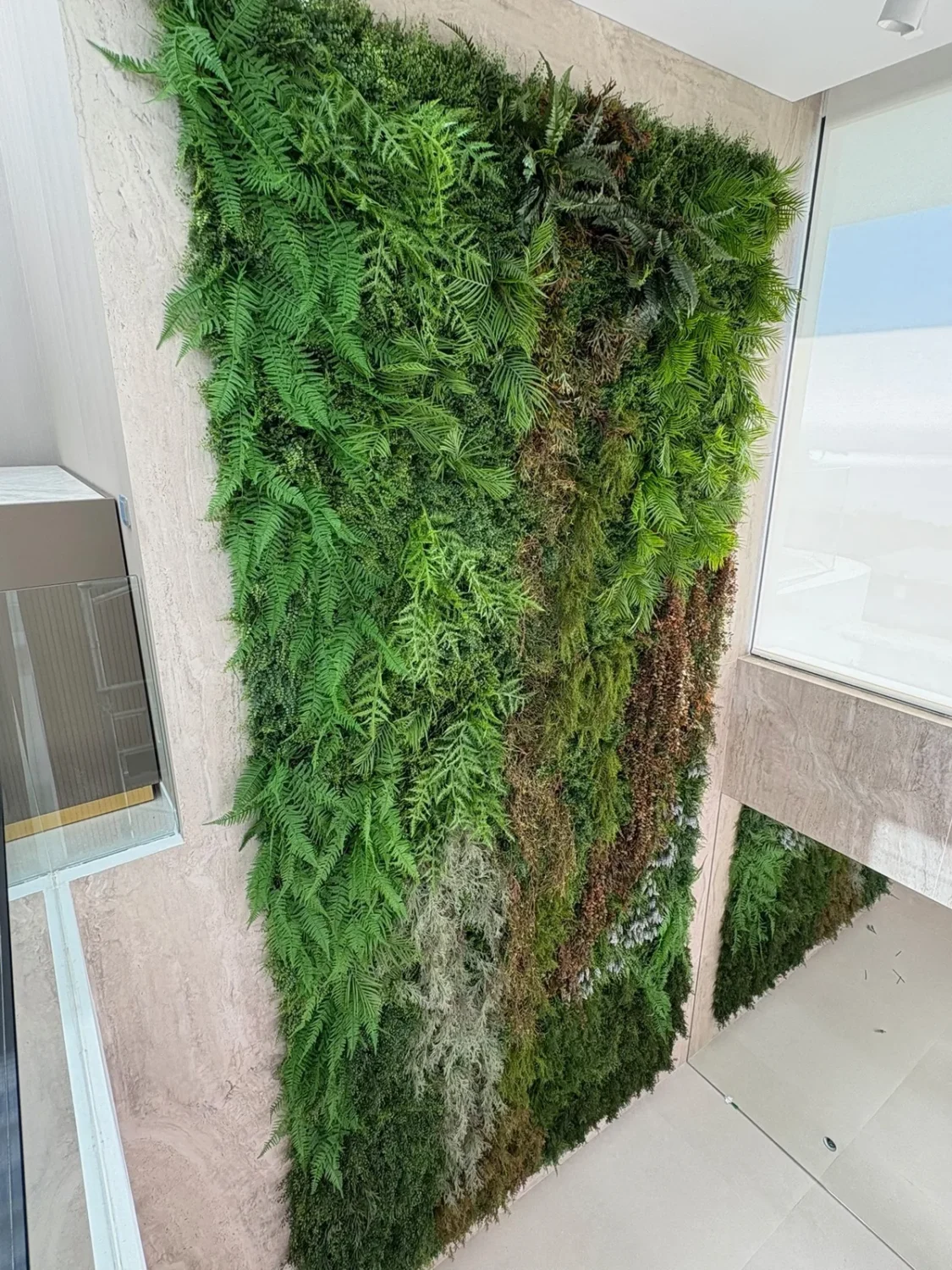 Jardín vertical decorativo con vegetación en tonos verdes y tierra