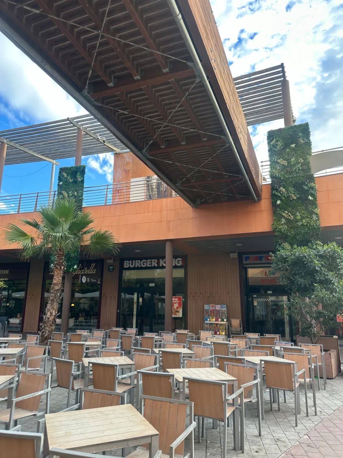 Jardín vertical artificial en fachada exterior junto a zona de restauración