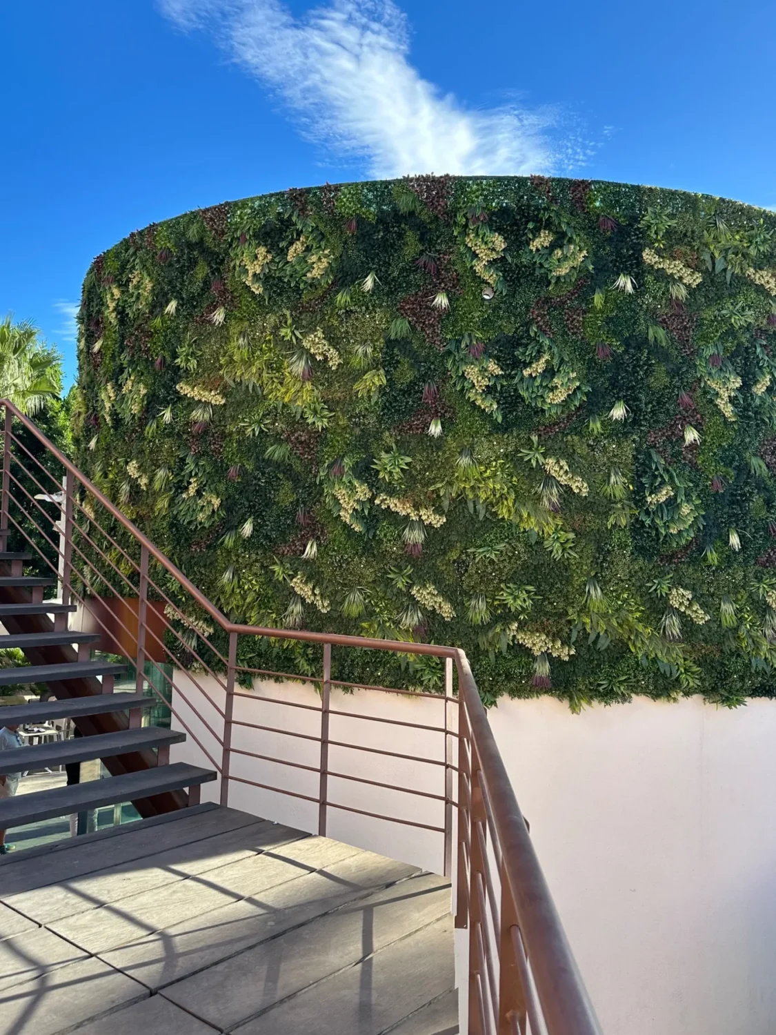 Jardín vertical artificial junto a escalera exterior